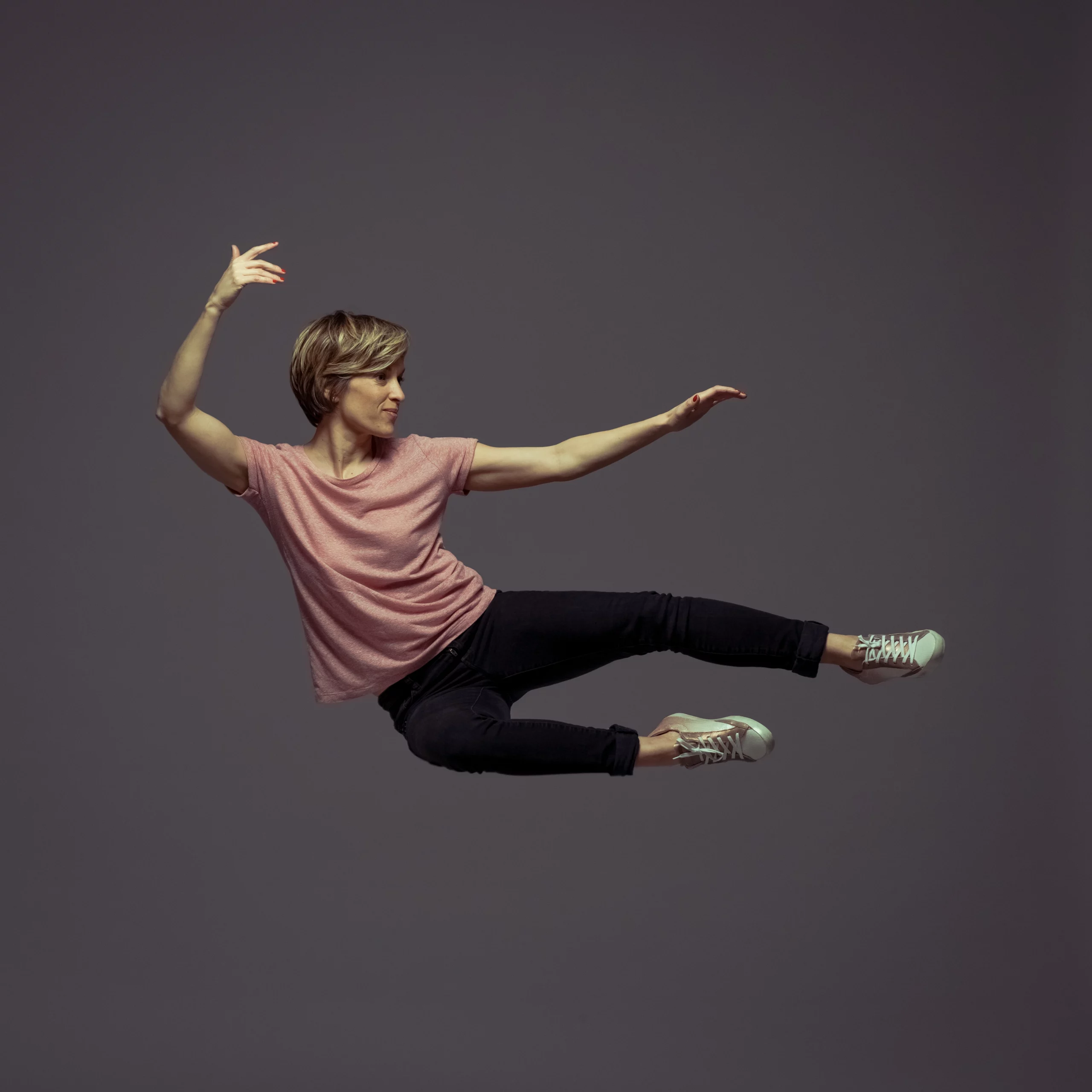Un saut dynamique et gracieux de Marina, fondatrice de la méthode Mov'Art®, illustrant la joie et la fluidité. En tenue décontractée, elle fusionne l'énergie de la danse contemporaine avec le bien-être corporel et le mouvement conscient.